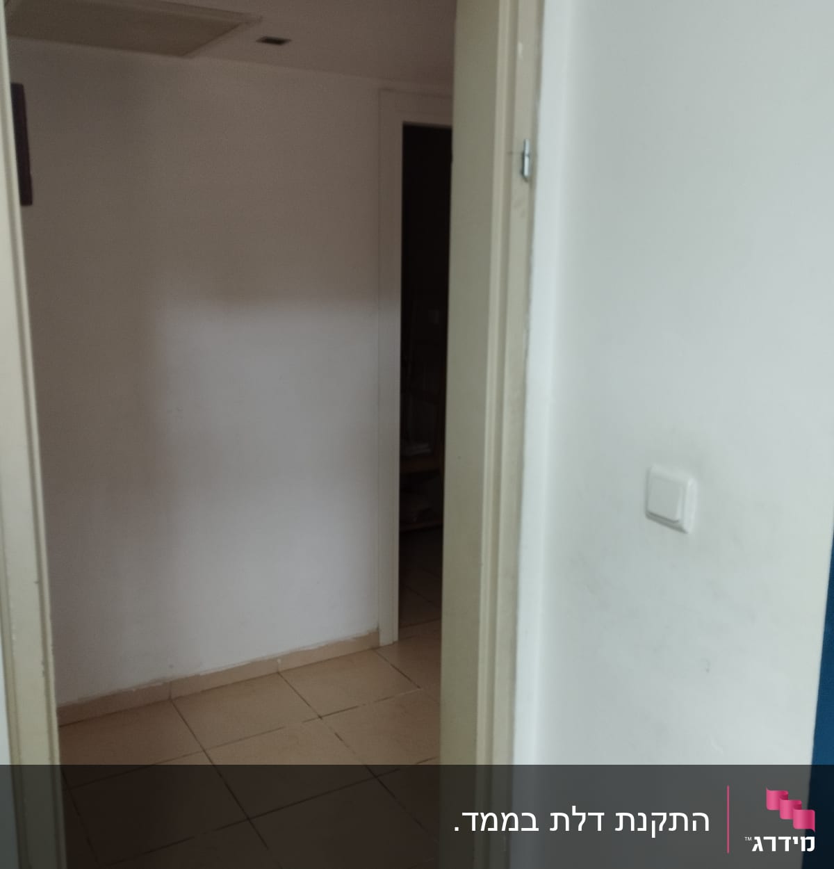 דלת פתוחה עם משקוף בהיר וקיר לבן